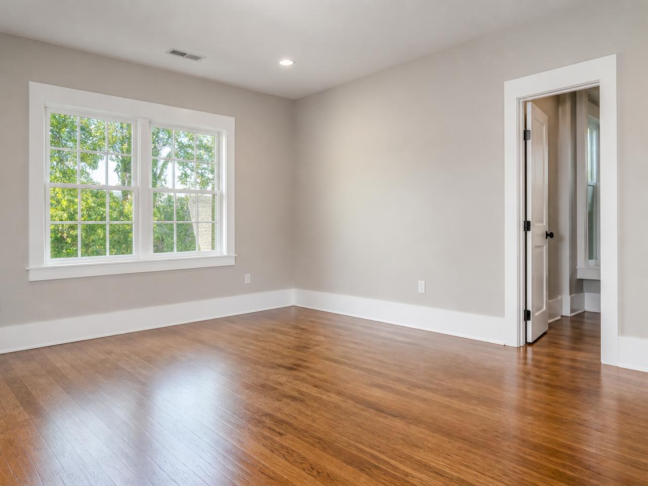 Empty Portland, Oregon remodel with newly installed white baseboards, smooth painted walls and hardwood flooring