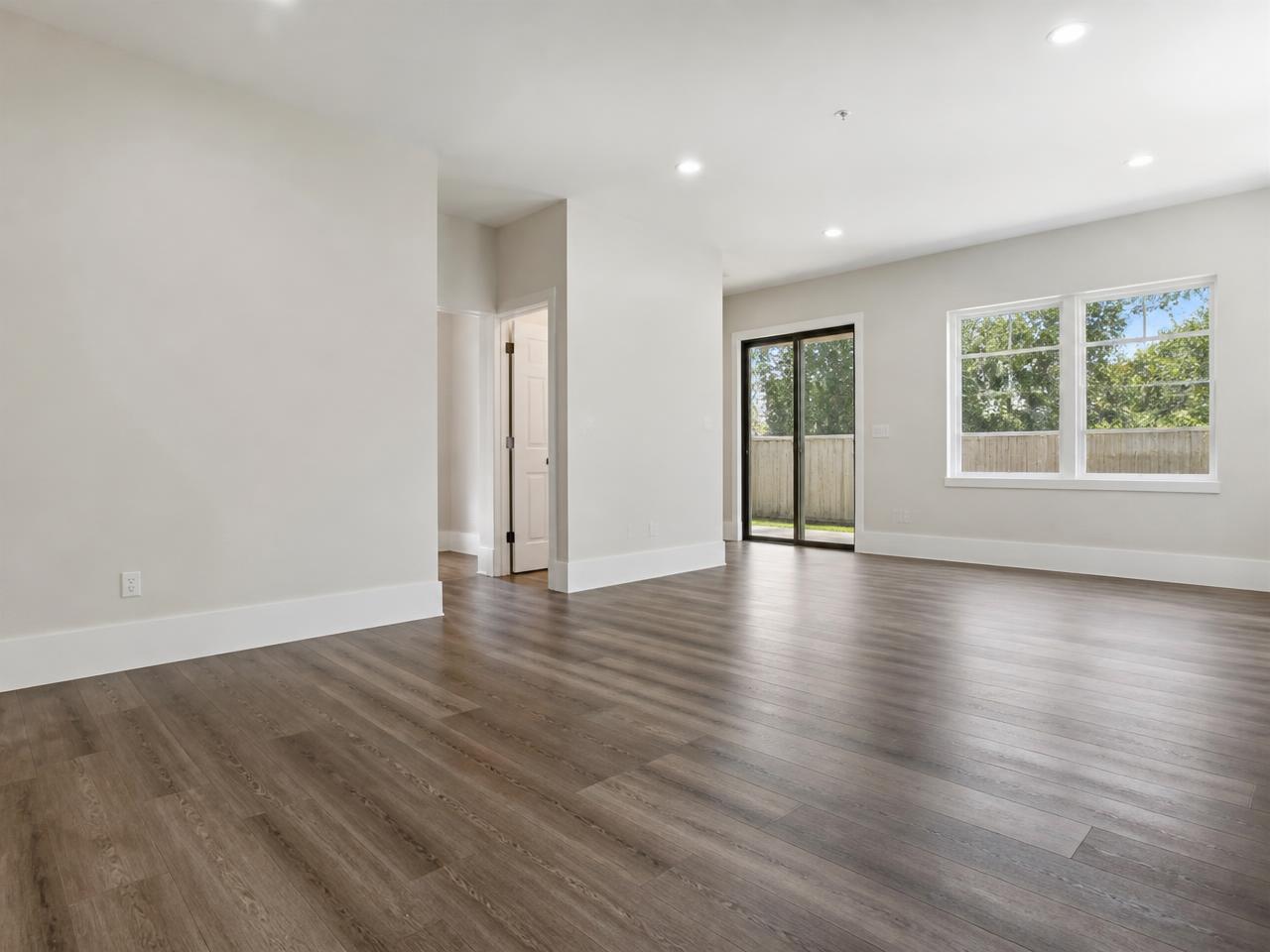 Empty remodeled Portland room with newly installed white baseboards, smooth painted drywall, and finished flooring